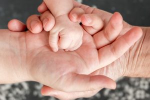 Timberwood Park Father's Rights Attorney Three hands parents and kid child 1 300x200